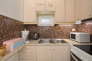 A kitchen with a microwave, coffee maker, and a bread box. - Icabaru Private House With Garden & Bbq, Near Laganas, Zakynthos (Zakynthos)