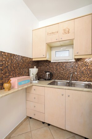 A kitchen with a coffee maker, a bread box, and a microwave.