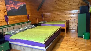 A cozy wooden cabin bedroom with two bunk beds, a green trash bin, and a painting of mountains. - Apartma Pohar- A Bit Different! (Bovec)