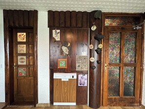 A wooden door with various decorative items and a dishwasher installed below it. - Apartma Pohar- A Bit Different! (Bovec)