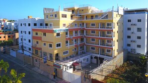 A multi-story hotel with balconies, air conditioning units, and a sign for 'Aparthotel'. - Room-single Room Near SDQ Airport 300 M (Santo Domingo Este)
