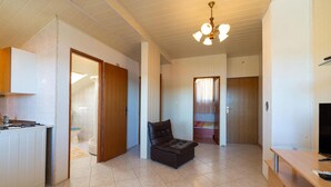 Un espacio habitable compacto con kitchenette, comedor y dormitorio.