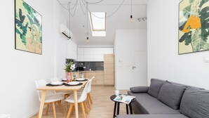 A modern apartment with a dining area, kitchen, and living room.