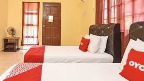 A hotel room with two beds, a wooden door, and a fan. - Oyo 90640 D'village River & Cafe Chalet (Kuala Tembeling)