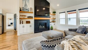Una sala de estar moderna con chimenea, estanterías de madera y un televisor grande.