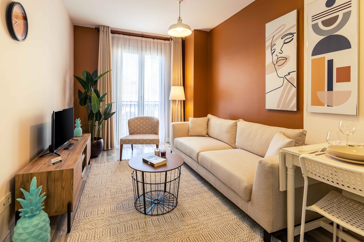 Un salon moderne avec un canapé, une table basse, un téléviseur et une lampe.