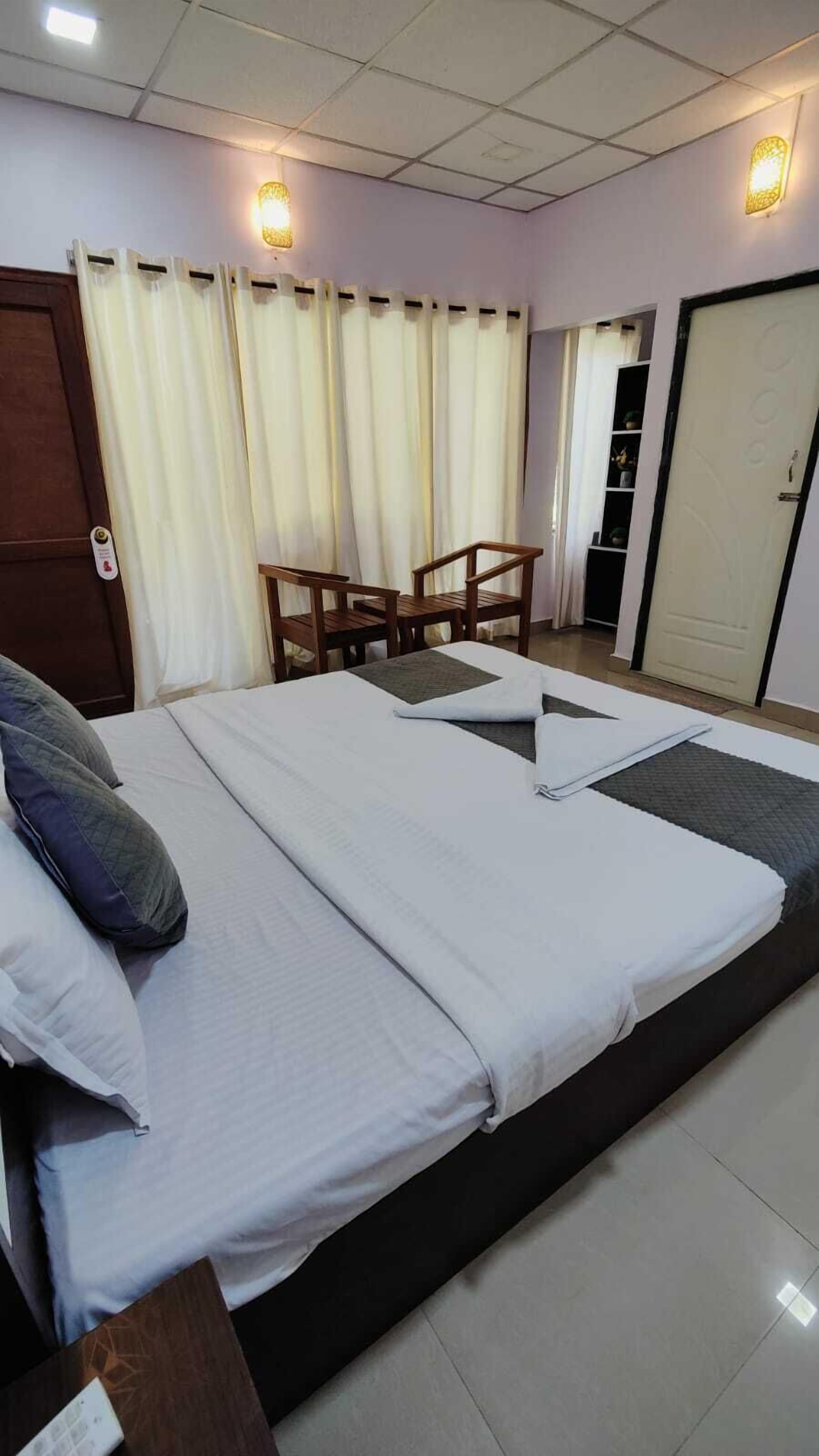 Una habitación de hotel con una cama, un escritorio, una silla y una puerta.