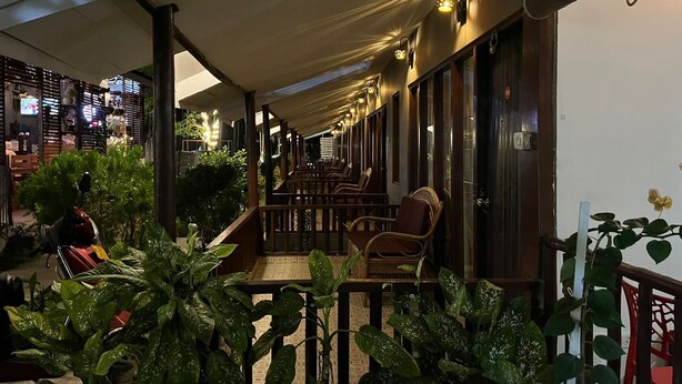 A covered outdoor seating area with wicker chairs and potted plants. - The Aroma Resort (Port Blair)