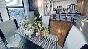 Una cocina moderna con armarios blancos, una isla central y taburetes de bar.