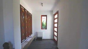Un pasillo estrecho con taquillas de madera a un lado y una ventana al otro.