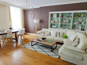 Un salon avec un canapé, une table basse et une bibliothèque.
