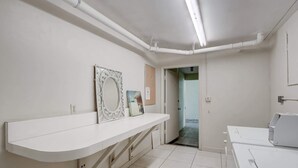 Een badkamer met een wit wastafelmeubel, een spiegel en een douchehoek.
