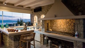 Une cuisine moderne avec un mur en pierre, un coin bar et une vue sur la mer.