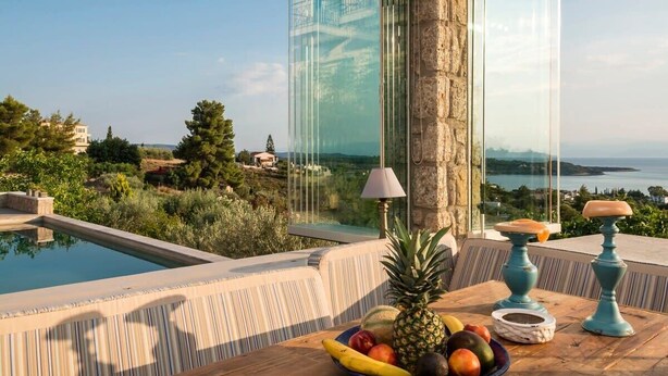 A poolside table with fruit and a lamp, overlooking a pool and scenic landscape. - Porto Cheli Studio - Poolside Lux Getaway (Porto Cheli)