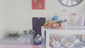 A table with various items including fruits, a water bottle, and a pitcher. - pousada estrela matutina (Pirenópolis)