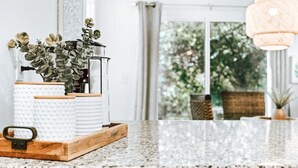A kitchen counter with a plant, a kettle, and a coffee maker.