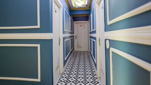 A hallway with blue walls, white trim, and a black and white patterned floor. - Royal Hotel-Kumkapi (Istanbul)
