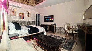 A modern hotel room with a bed, a sofa, a TV, and a desk. - Royal Hotel-Kumkapi (Istanbul)