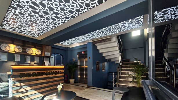 A reception area with a wooden reception desk, a clock, and a staircase. - Royal Hotel-Kumkapi (Istanbul)