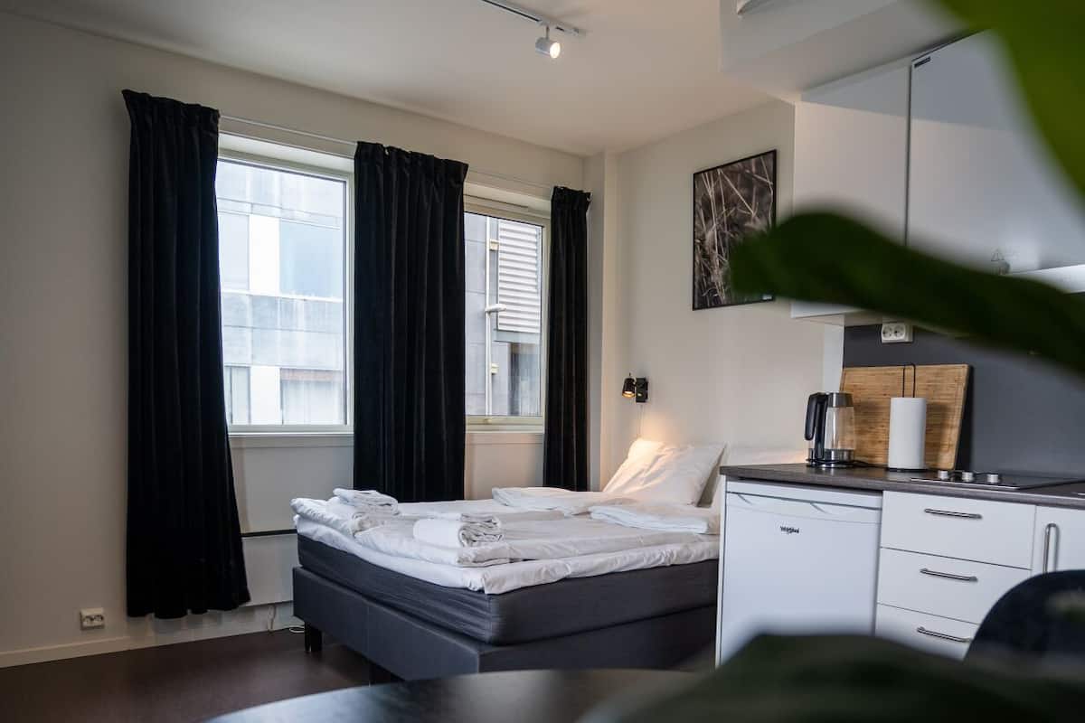 A modern bedroom with a bed, bedside table, and a dresser.