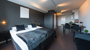 Ein modernes Hotelzimmer mit einem großen Bett, einem Schreibtisch und einem Essbereich.