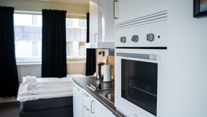 Eine moderne Küche mit Einbauofen und Mikrowelle, einer Kaffeemaschine sowie einem Essbereich mit Tisch und Stühlen.