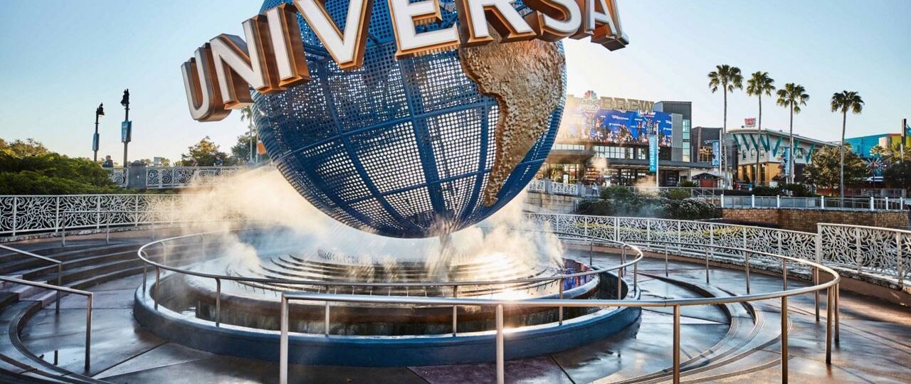 A large globe with the word "UNIVERSAL" in the center, surrounded by a circular water feature and a decorative fence.