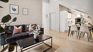 A modern living room with a sofa, coffee table, and artwork on the wall. - 70 Degrees North Apartment (Tromsø)