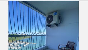 Un balcone con vista su una marina, un tavolo con sedie e un condizionatore d'aria.