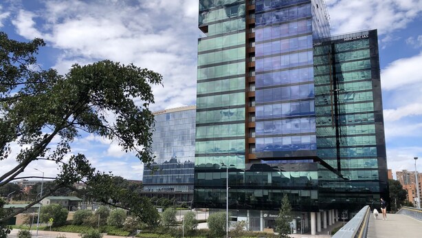 A modern building with reflective glass windows and a prominent entrance. - SalitreCondo (Bogotá)