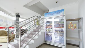A hotel lobby with a staircase, a refrigerated display case, and a sofa. - Hotel Pritty (Kuala Lumpur)