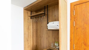 Un armario de madera con barra para colgar, estantes y un cajón pequeño.