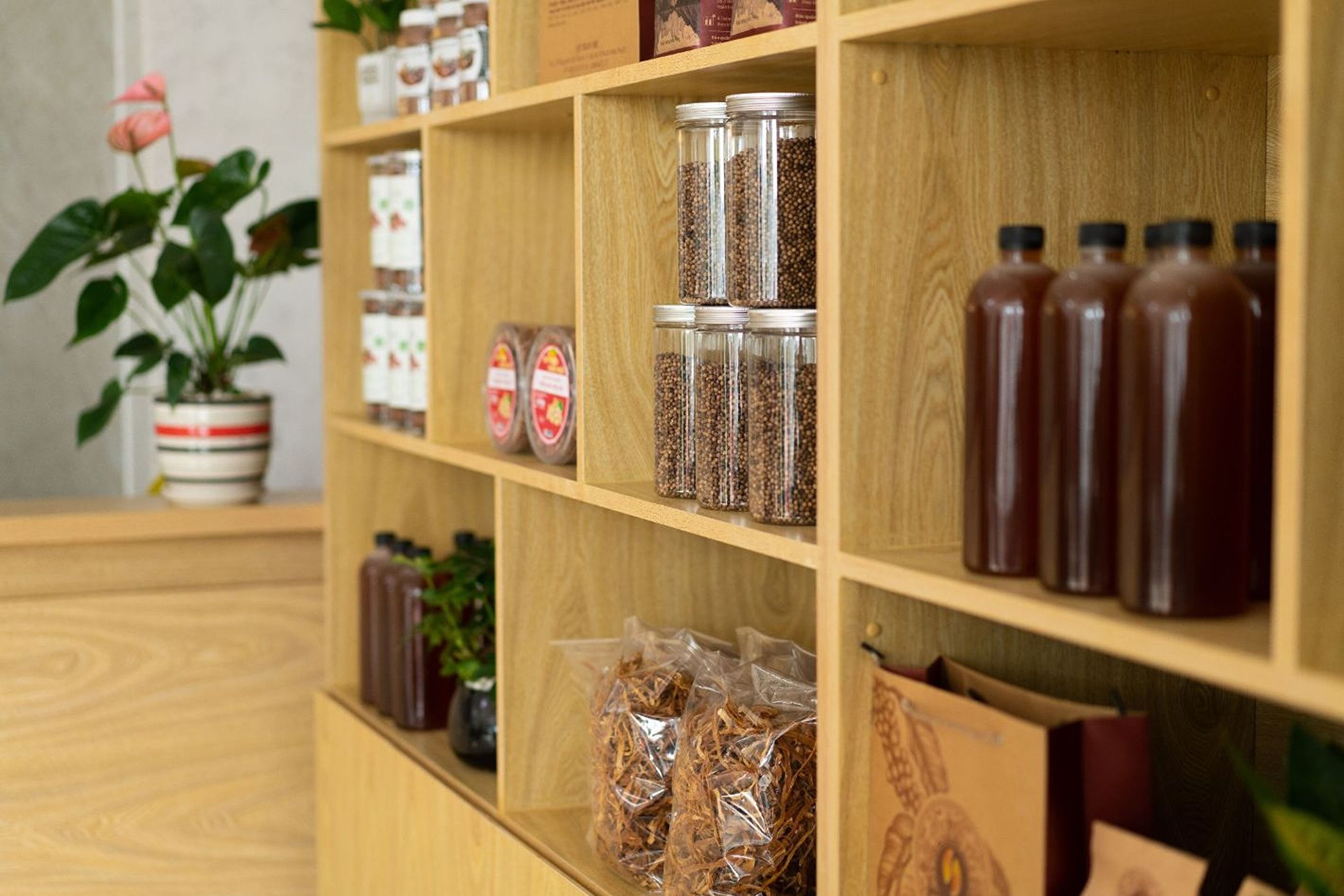 A wooden shelf with various jars and bottles, likely containing spices or condiments.