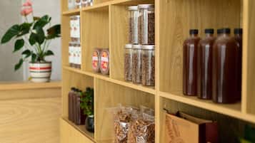 A wooden shelf with various jars and bottles, likely containing spices or condiments.