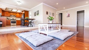 A spacious living area with hardwood flooring, a dining table with chairs, a white coffee table, and a gray rug. - Maison du Lavande, artzy 4Br House, gateway 2 Napa (Vallejo)