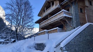 Un edificio de madera de varios pisos con balcones y fachada de piedra.