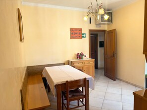 Habitación de hotel con cama, una mesa de madera, una silla, un aparador y una araña.