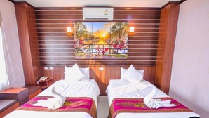 A hotel room with two beds, a painting of a sunset over a bridge, and an air conditioning unit above the beds. - Bander Hotel (Phu Khiao)