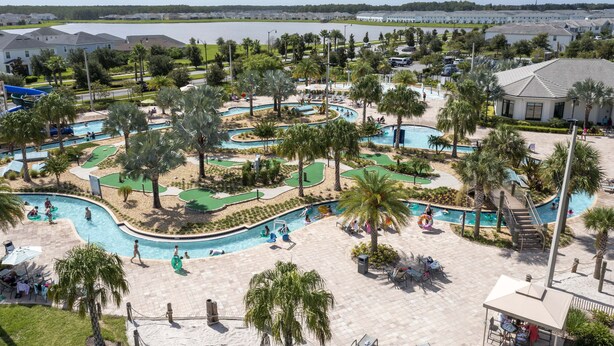 A resort with multiple swimming pools, palm trees, and a view of the water. - Grand Opening! 9BD/5BA-Storey Lake Resort/Lake View/GameRoom (Kissimmee)