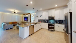 A modern kitchen with white cabinetry, stainless steel appliances, and a central island. - Grand Opening! 9BD/5BA-Storey Lake Resort/Lake View/GameRoom (Kissimmee)