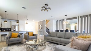 A modern living room with a grey sofa, two armchairs, a glass coffee table, and a patterned rug. - Grand Opening! 9BD/5BA-Storey Lake Resort/Lake View/GameRoom (Kissimmee)