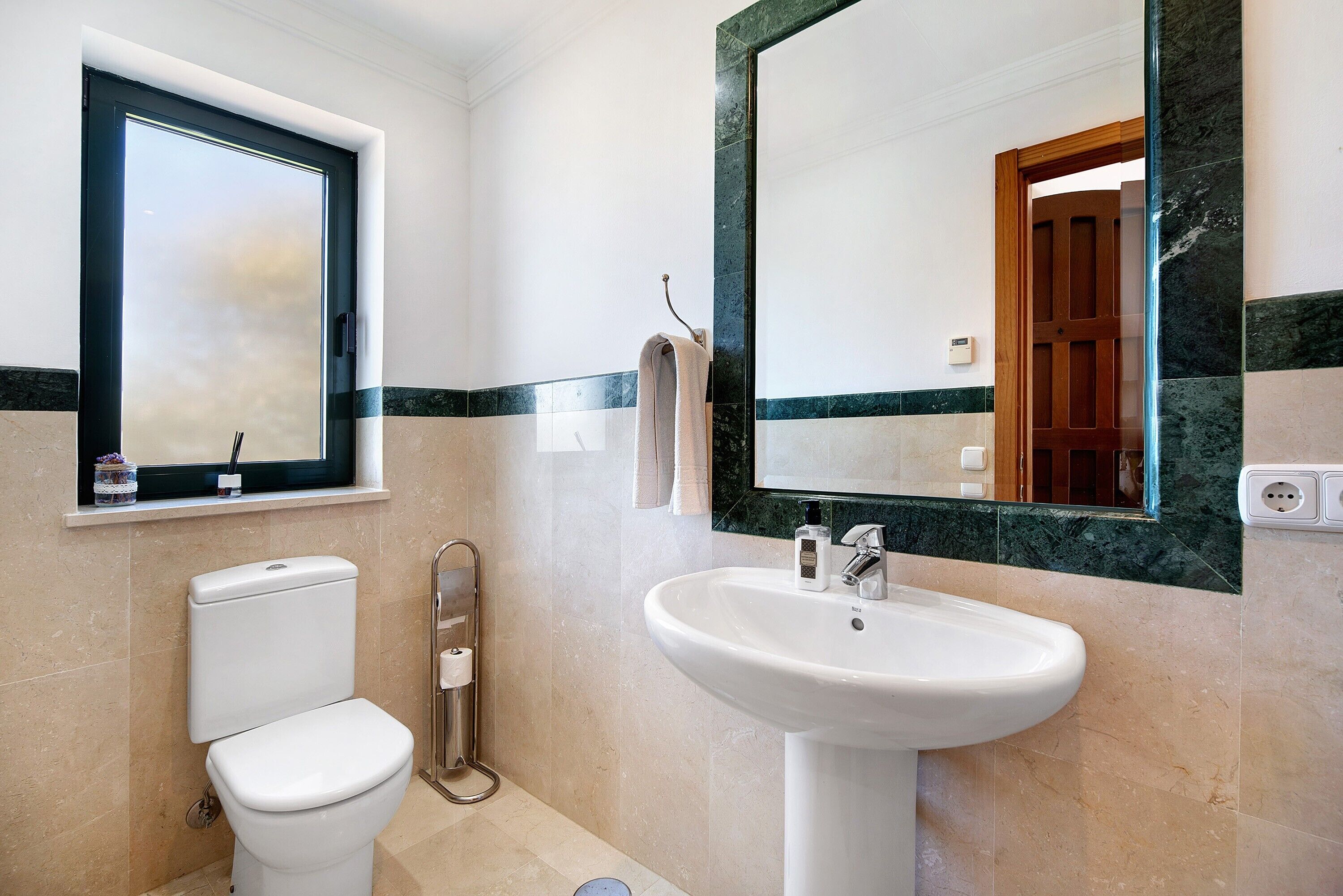 Une salle de bain avec des toilettes, un lavabo et un miroir.