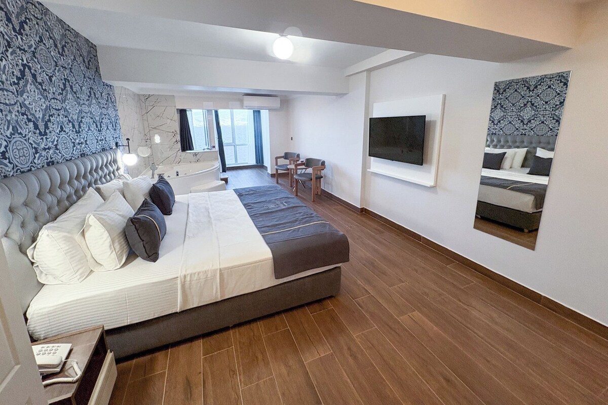 Un dormitorio moderno con una cama grande, televisión integrada y vista al mar.