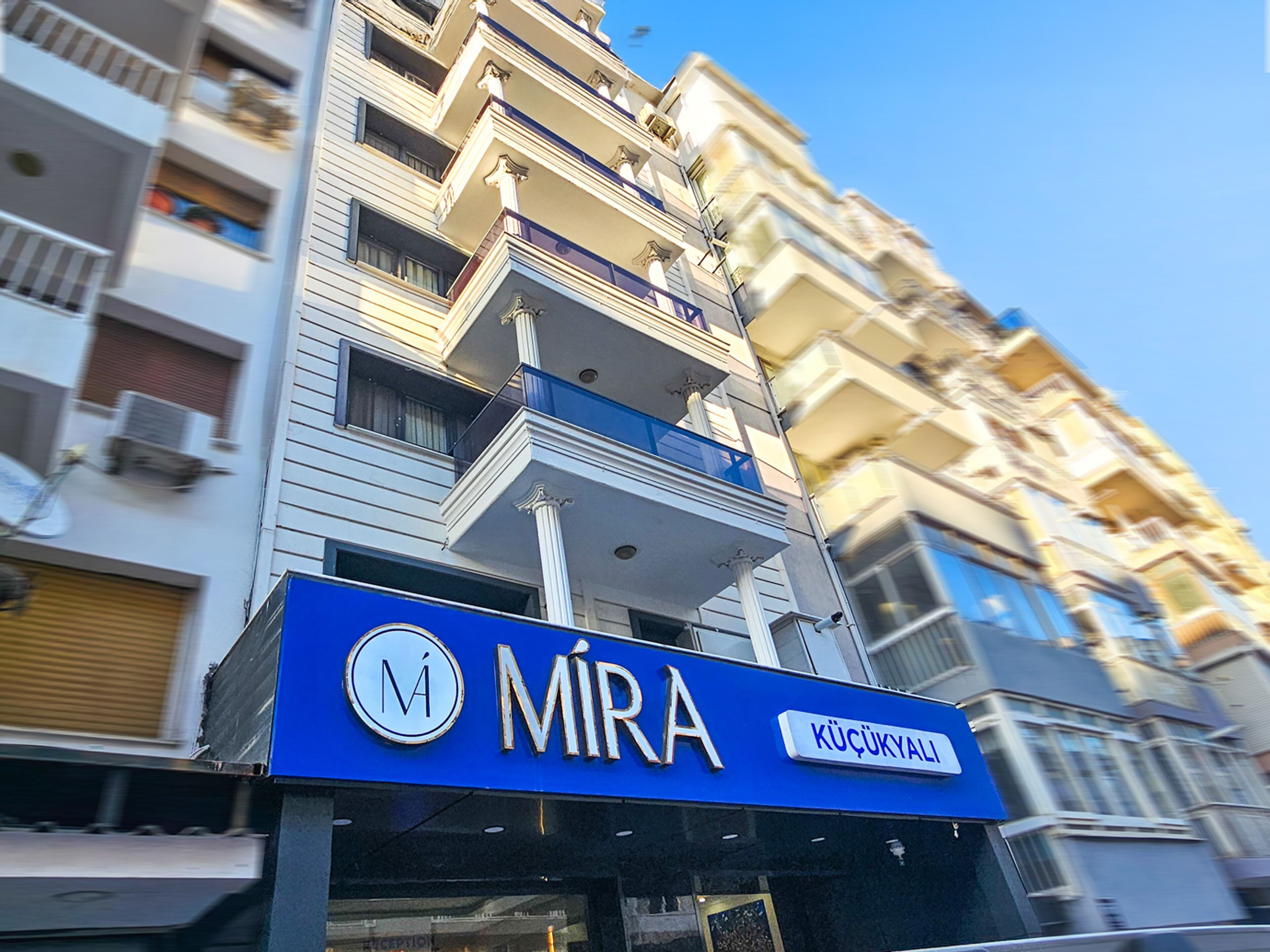 Un edificio con un letrero azul que dice 'MIRA' y 'KÜÇÜKYALI'.