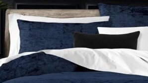 A bed with a dark blue headboard and white bedding.