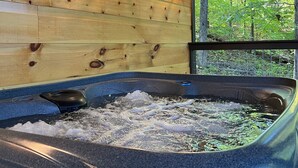 A wooden cabin interior with a hot tub, wooden walls, and two wall-mounted lanterns. - Quiet Mountain Escape Between Pigeon Forge and Gatlinburg (Sevierville)