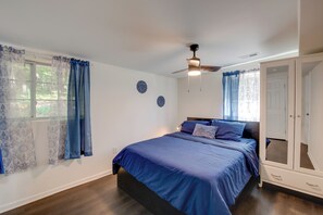 Ein Schlafzimmer mit Bett, Deckenventilator und Kleiderschrank.
