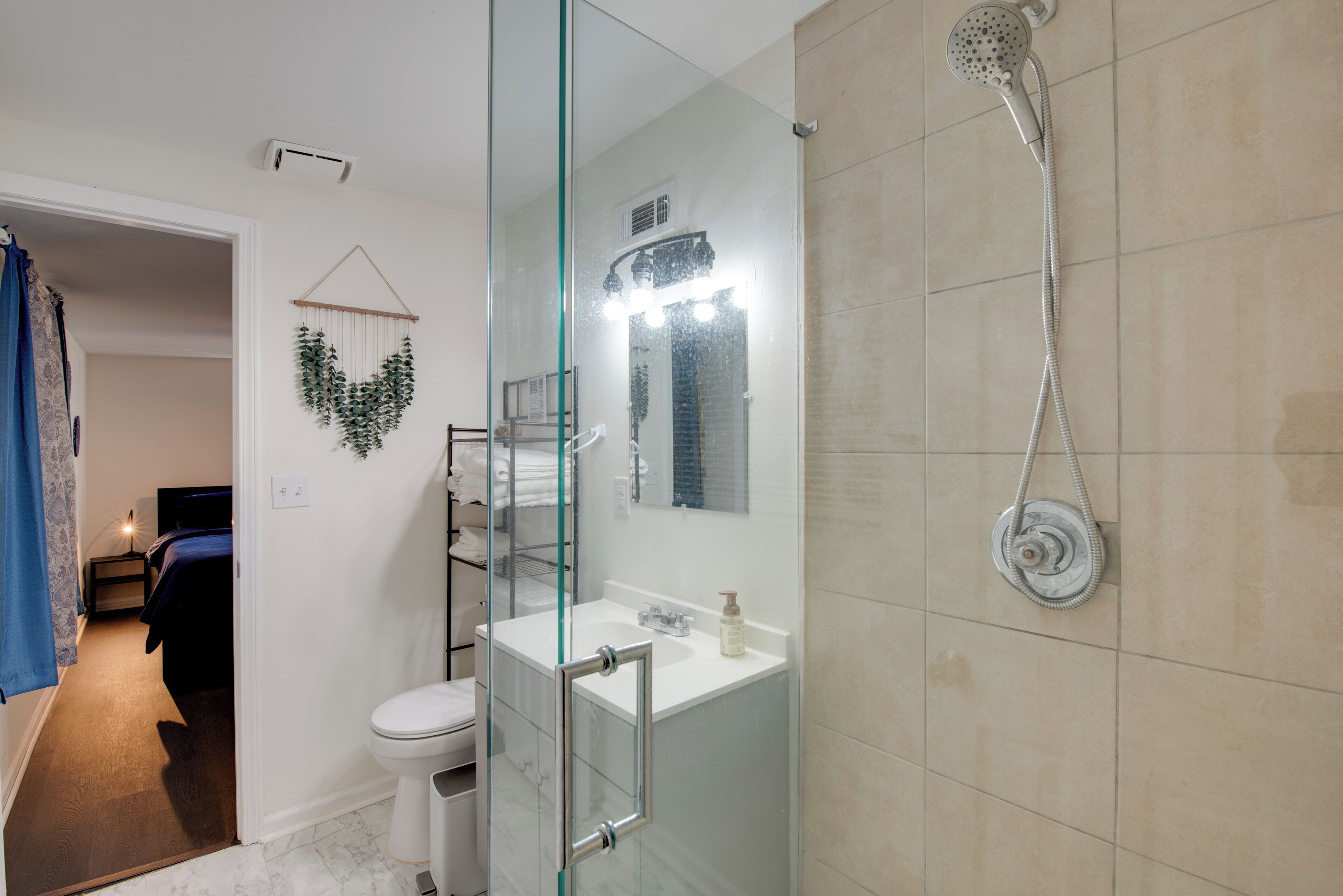A modern bathroom with a glass shower enclosure, a white sink, and a toilet.