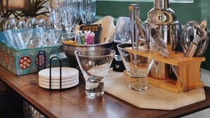 A bar area with cocktail glasses, a bottle of liquor, and bar tools. - Tranquil Avondale Home, Walkable to Food & Shops! (Jacksonville)