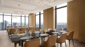 Un comedor moderno con amplios ventanales, techos altos y luminarias contemporáneas.